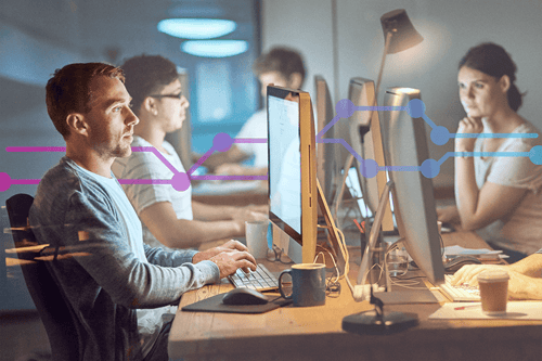 Shot of a group of young people using computers during a late night in a modern office